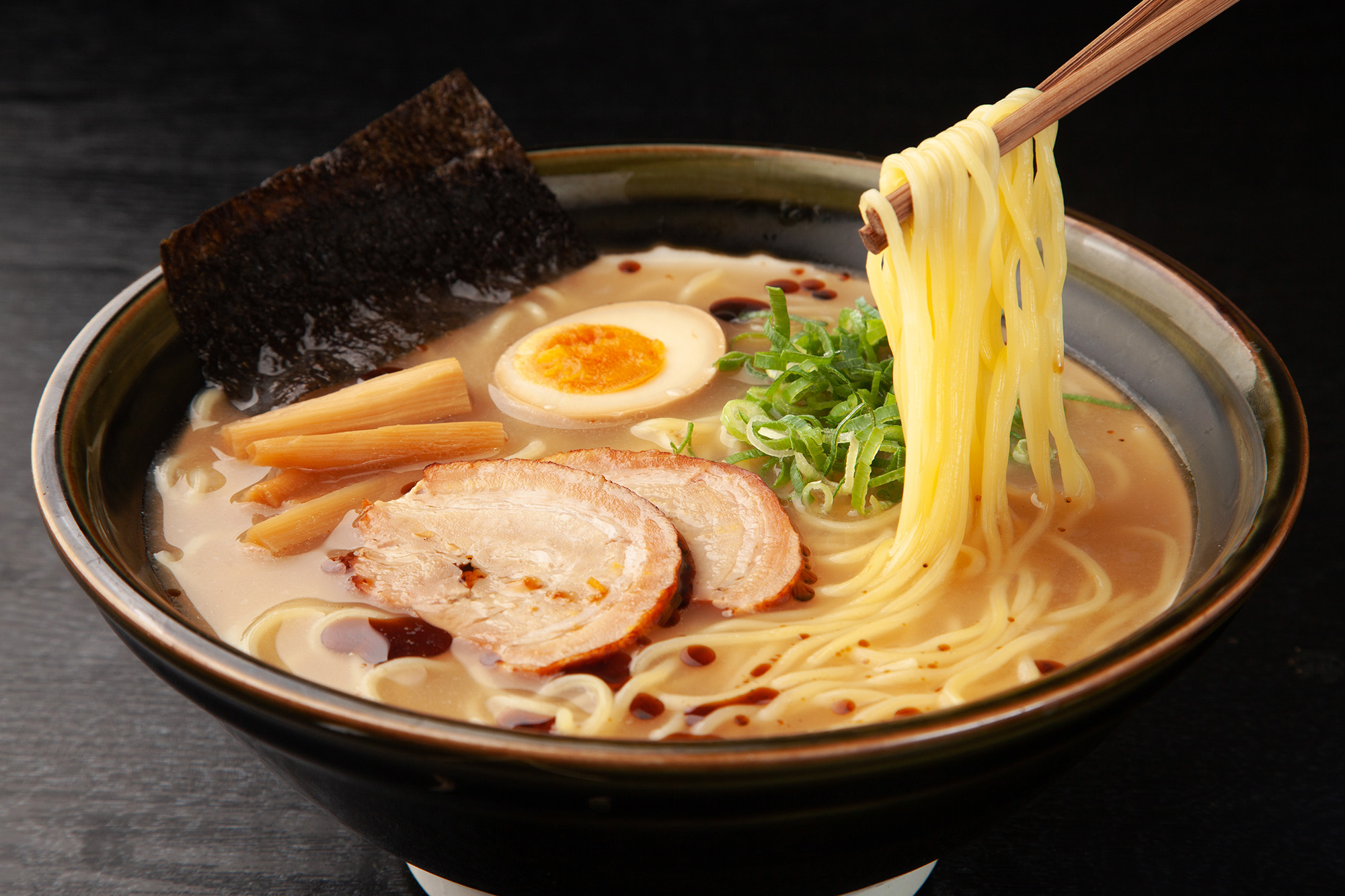 bowl of Amoy noodles with pork protein and boiled egg half