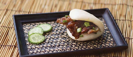 Plate of foodservice Amoy Asian Barbeque Pulled Pork Bao in a restaurant setting