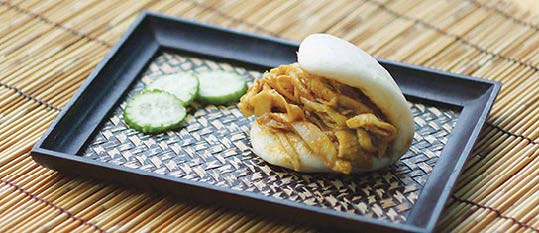 Plate of foodservice Amoy Asian Curry Chicken Salad Bao in a restaurant setting