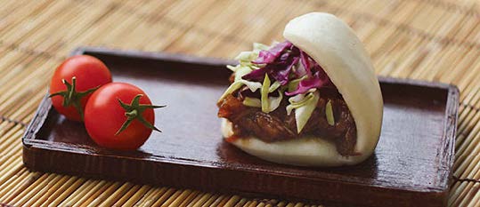 Plate of foodservice Amoy Asian Thai Grilled Chicken Satay Bao in a restaurant setting
