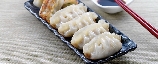 row of Hong Kong style potstickers in a black dish
