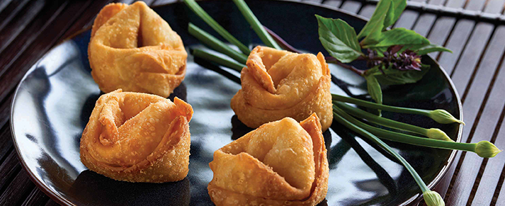 Plate of foodservice Amoy Asian Crab Rangoons in a restaurant setting