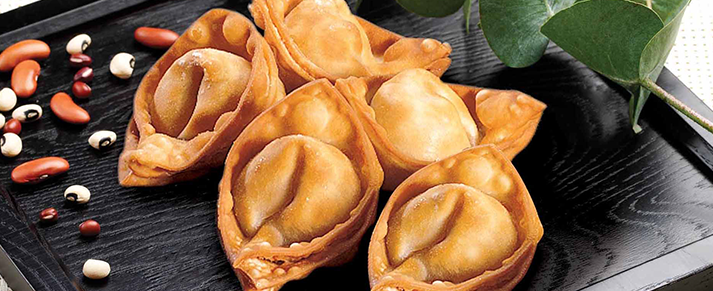 Plate of foodservice Amoy Asian Buffalo Chicken Rangoons in a restaurant setting